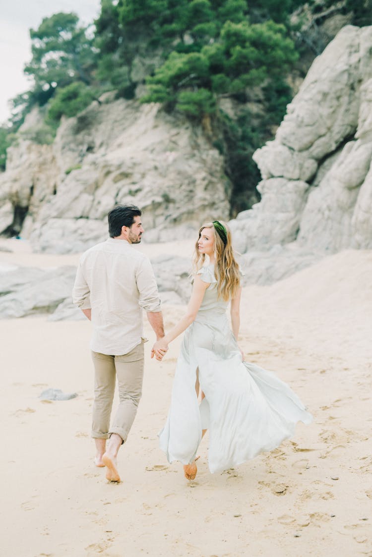 Back View Of A Couple Walking On The Sand