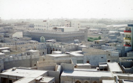 An expansive aerial view of traditional Middle Eastern buildings under a hazy sky.