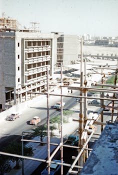 A high-angle view of a vintage construction site with vehicles on the road in Kuwait.