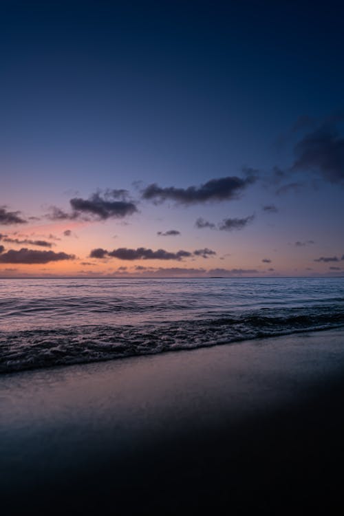 Sea Waves Crashing on Shore During Sunset