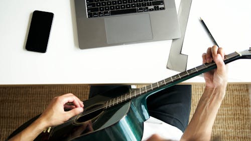 Kostnadsfri bild av akustisk gitarr, bärbar dator, gitarrist