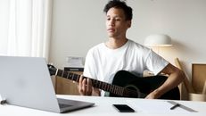 Man in White Crew Neck T-shirt Playing Guitar