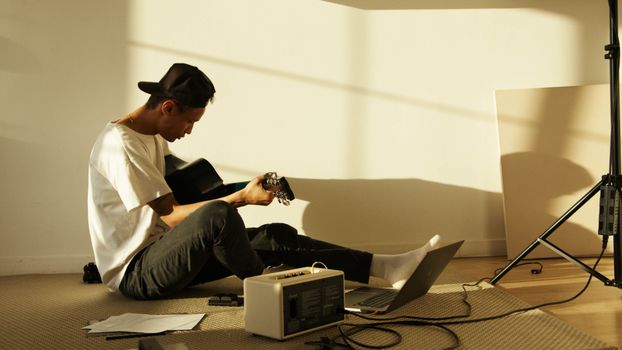 Man in White Dress Shirt and Black Pants Sitting on Chair Using Macbook Pro