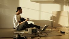 Man in White Button Up Shirt and Black Pants Sitting on Brown Sofa