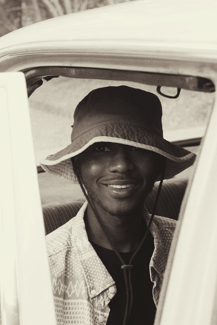 Smiling Black Man In Bucket Hat Sitting In Car