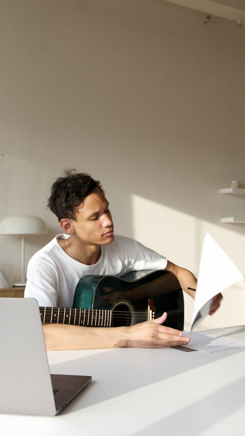 Man with a Guitar Reading a Paper