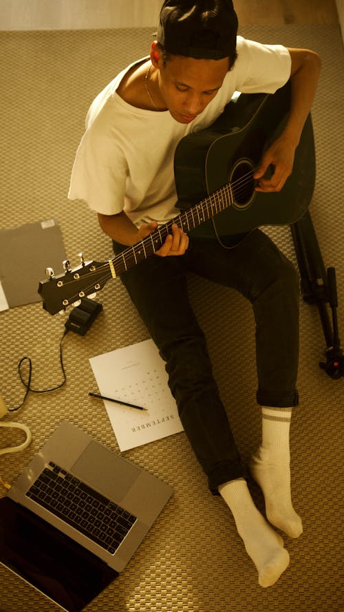 Man in White Shirt Playing a Guitar