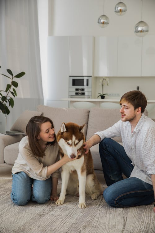 Free Man and Woman Showing Affection To Their Dog Stock Photo