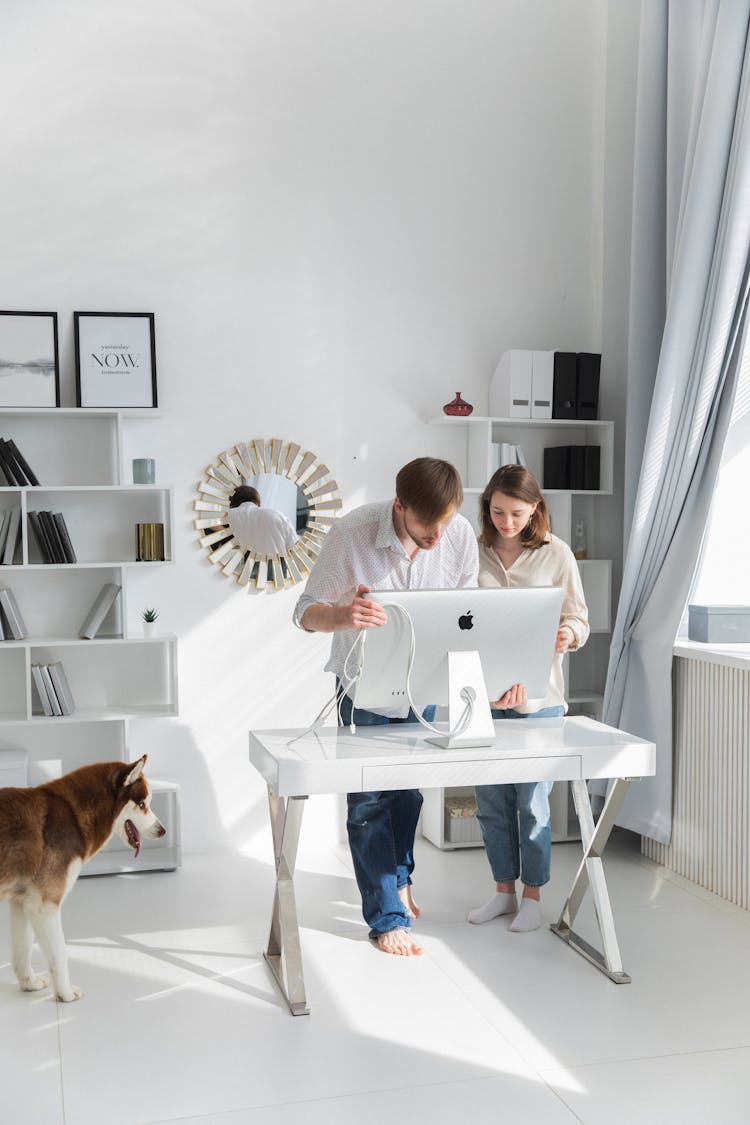 Couple Setting Up Computer On Desk