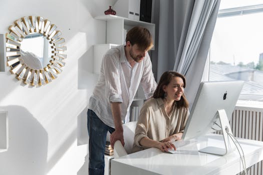 A couple working together in a bright home office with an Apple computer, fostering teamwork and creativity.