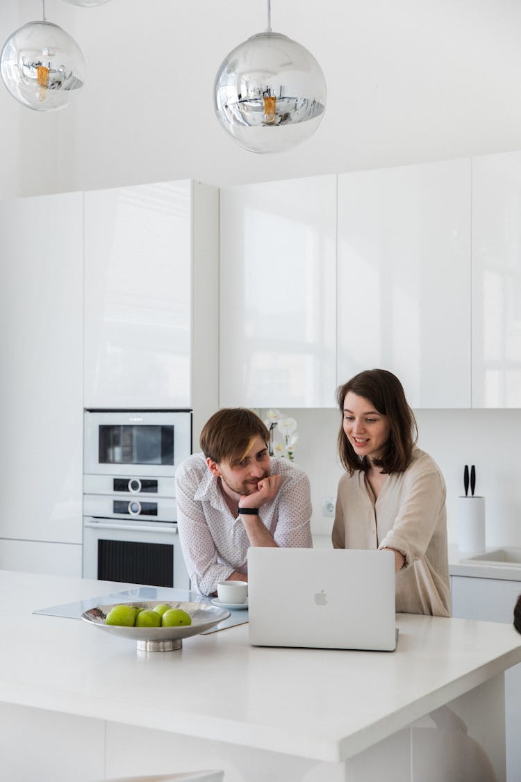 Couple With Laptop In Kitchen