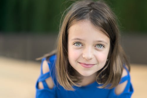 Free Smiling young girl in blue shirt Stock Photo