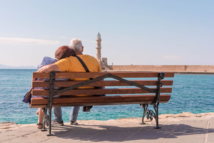 Back View Of An Elderly Couple Sitting On A Bench