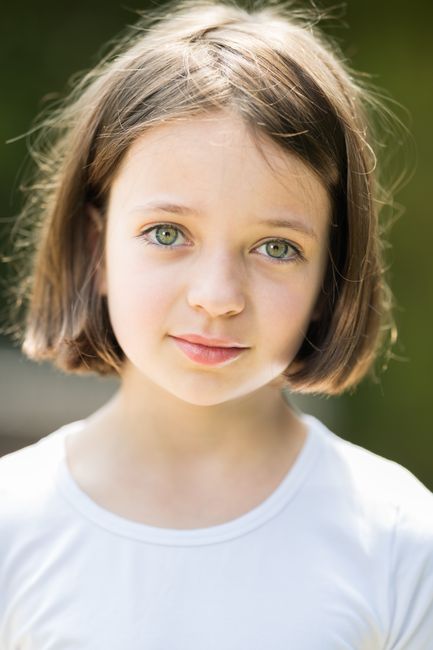 Adorable portrait of a young girl with short hair and beautiful eyes in natural lighting.