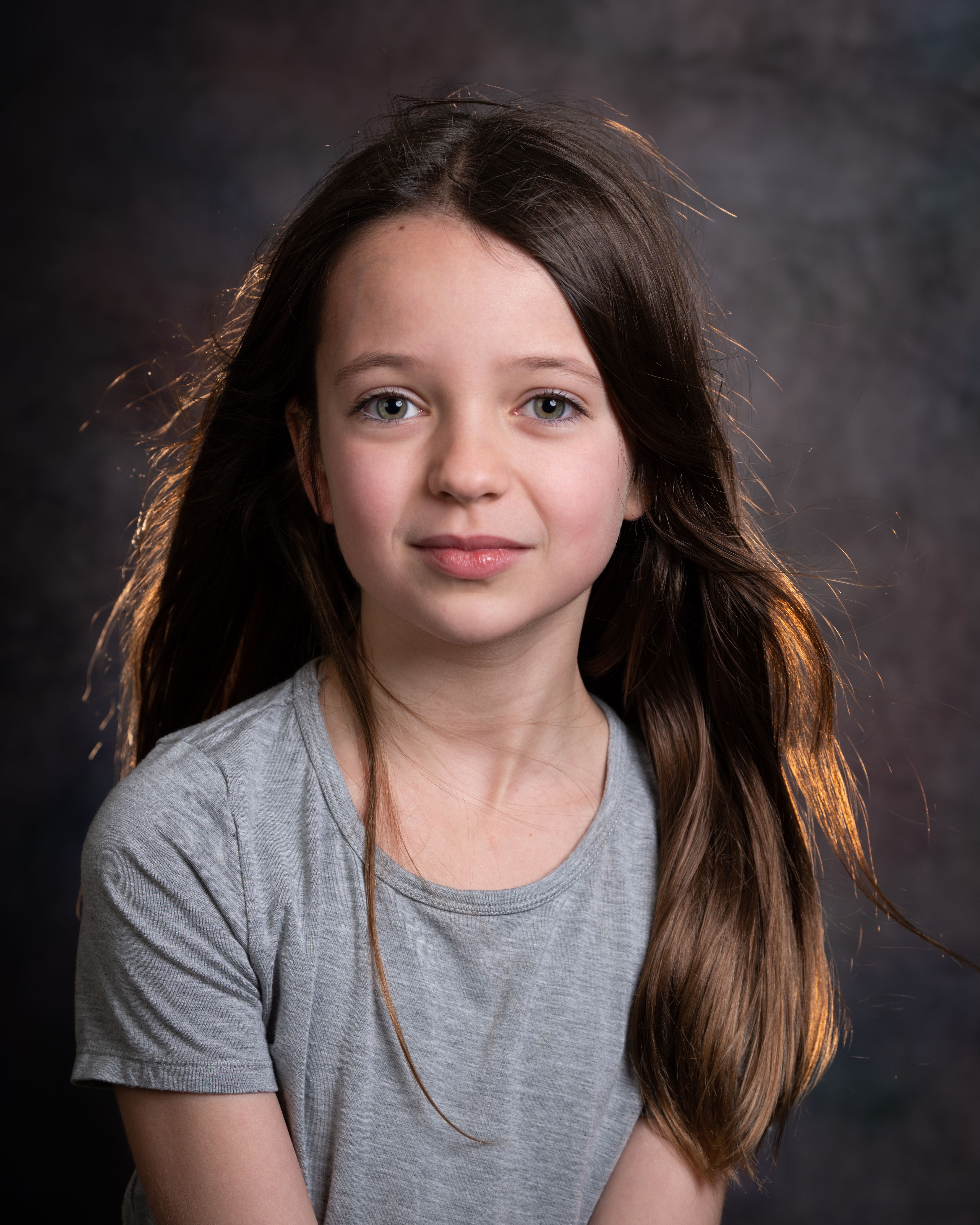Charming portrait of a young girl with long hair and a pensive look.