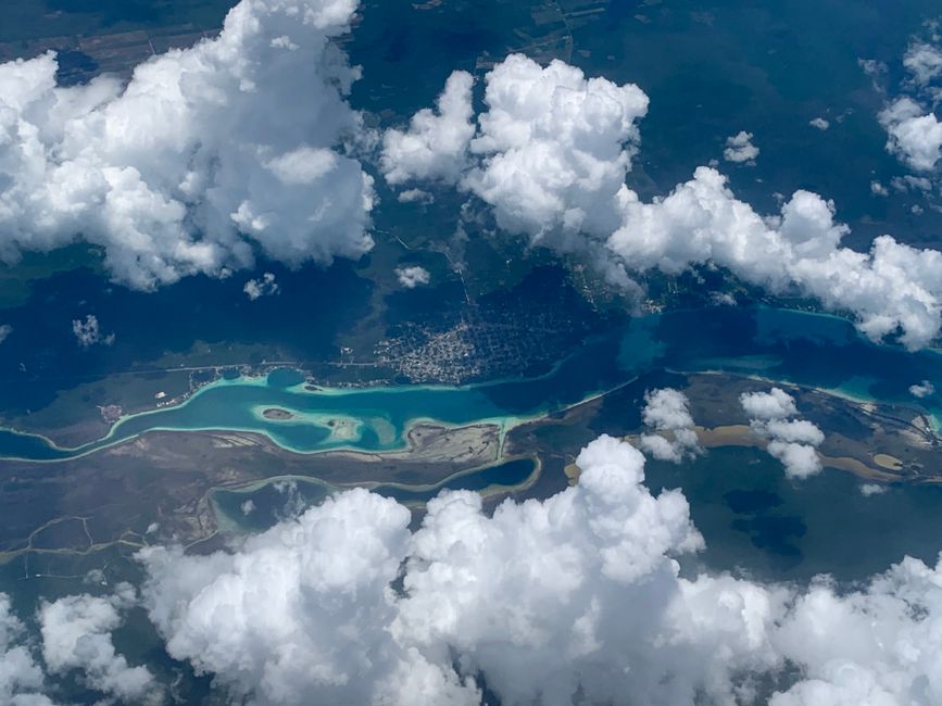 Outstanding Family Pack 48 Miles Helicopter Tour over Theme Parks & Downtown Review 2026 - Breathtaking aerial view of Mérida's coastline with scattered white clouds and turquoise waters.