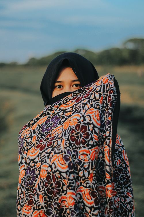 Free Woman in a floral hijab outdoors in Jawa Timur, Indonesia, showcasing cultural attire. Stock Photo