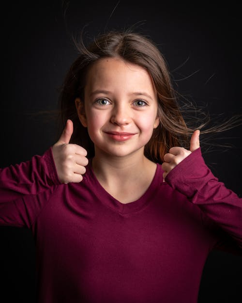 Free Girl in Red Long Sleeves While Doing Thumbs Up Stock Photo