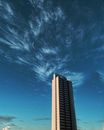 一座高大的现代建筑矗立在繁星点点的夜空中