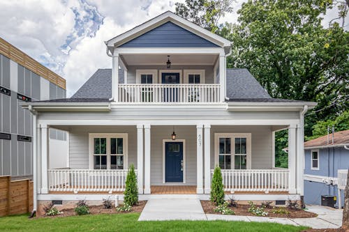 White and Brown Wooden House With Balcony Over A Porch