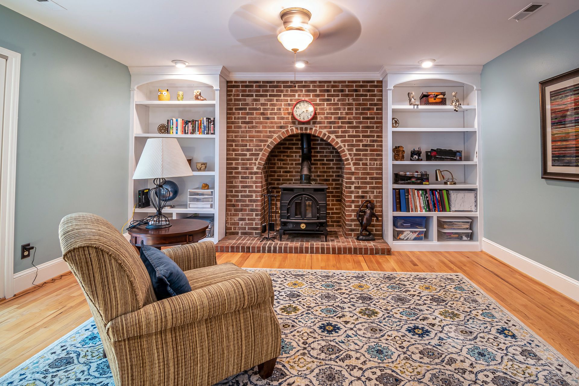 Cozy living room interior with brick fireplace and elegant furniture setup.