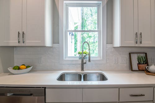 Photo of Faucet and Sink Near White Wooden Framed Glass Window