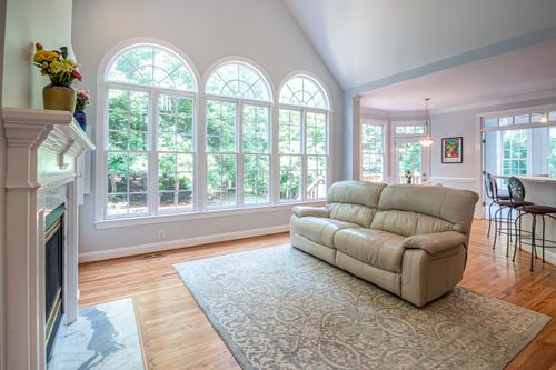 Free Spacious living room with large arched windows and comfortable sofa. Stock Photo
