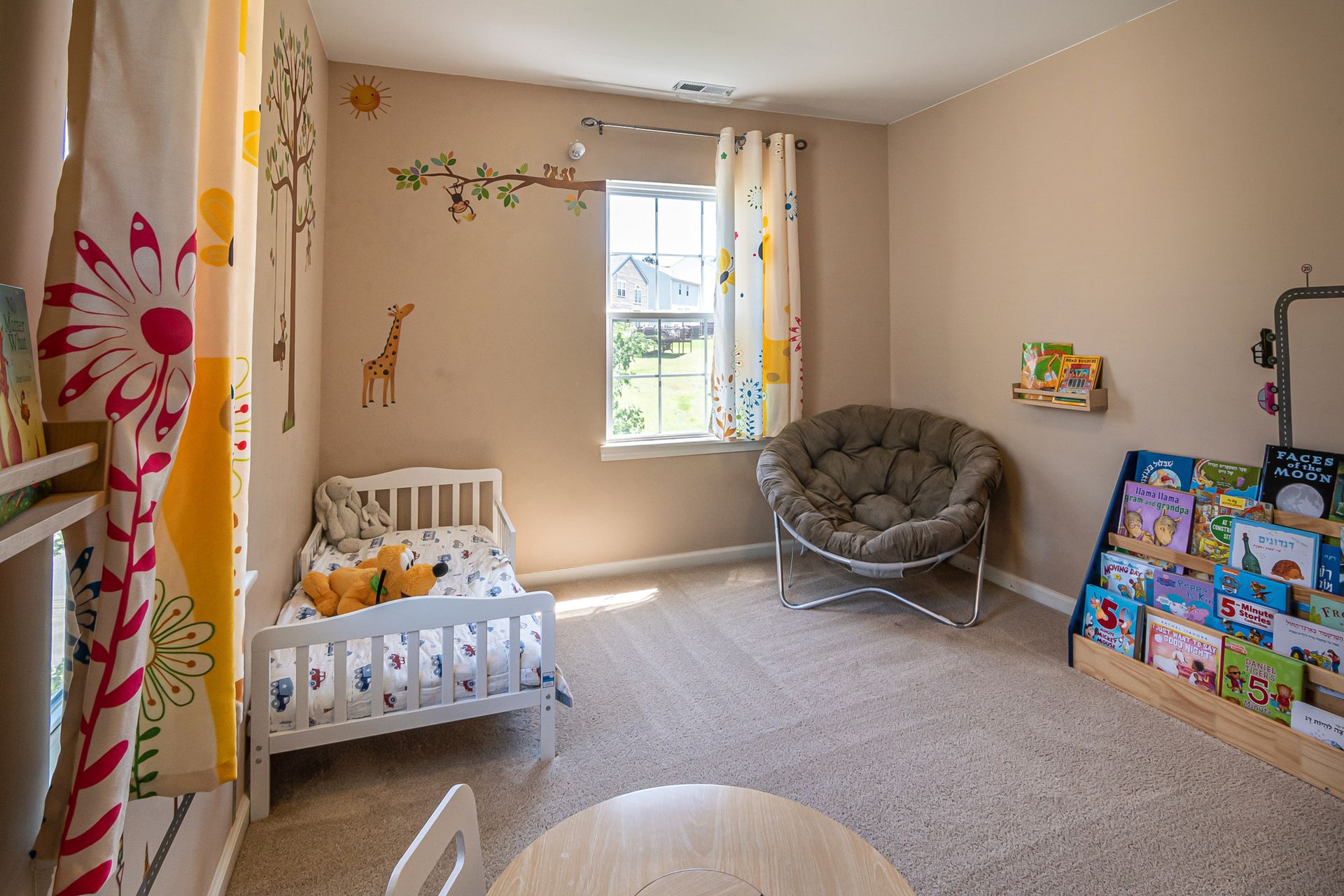 A well-designed kids' room featuring a cozy bed, playful decor, and colorful bookshelf in a bright setting.