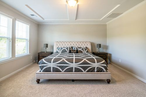Free Spacious modern bedroom featuring a stylish bed and ample natural light. Stock Photo