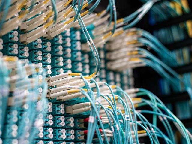 Technician labeling network cables in a server closet