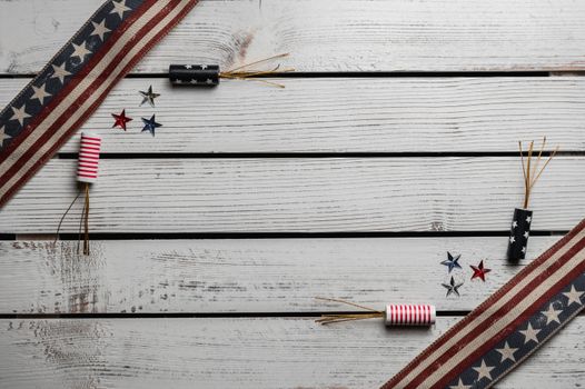 From above of fireworks and tiny multi colored stars between long narrow Flags of United States at angle