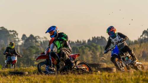 Free Dynamic motocross action capturing bikers racing on dirt track outdoors. Stock Photo