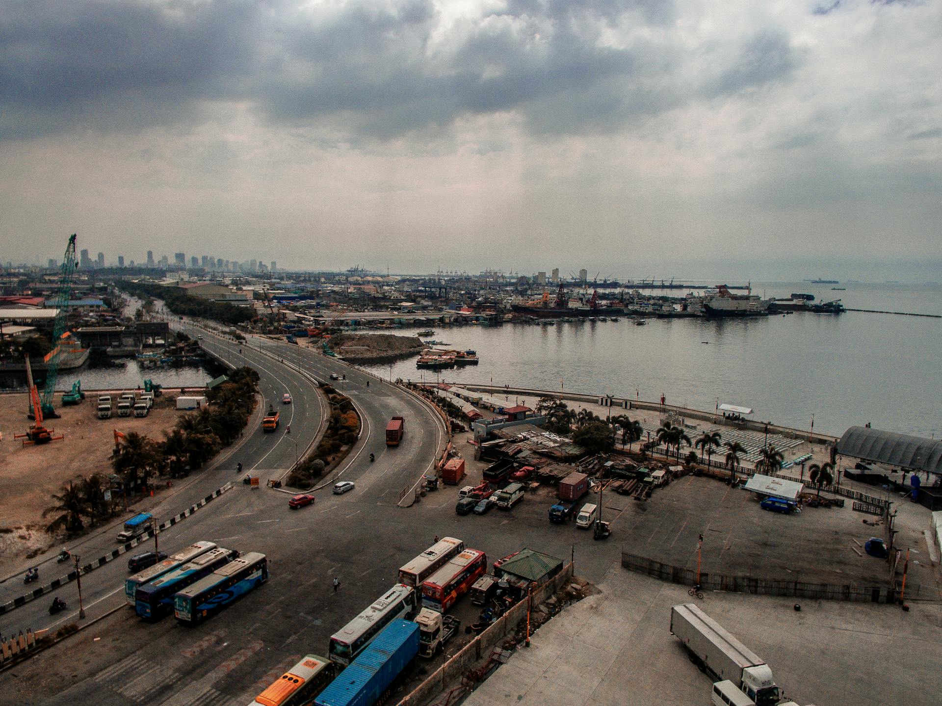Aerial view of a busy port and highway near Manila Bay in the Philippines, showcasing urban traffic.