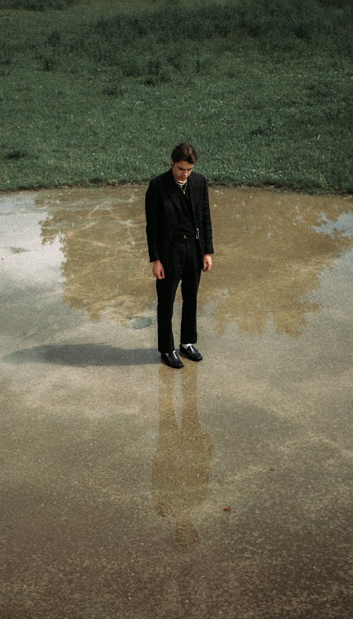 Gratis Hombre Melancólico En Traje De Pie Sobre Suelo Húmedo En El Parque Foto de stock