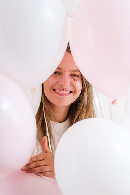 Smiling Woman Holding White Balloons