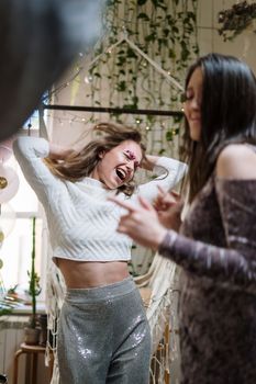 两名妇女在室内的庆祝活动中载歌载舞