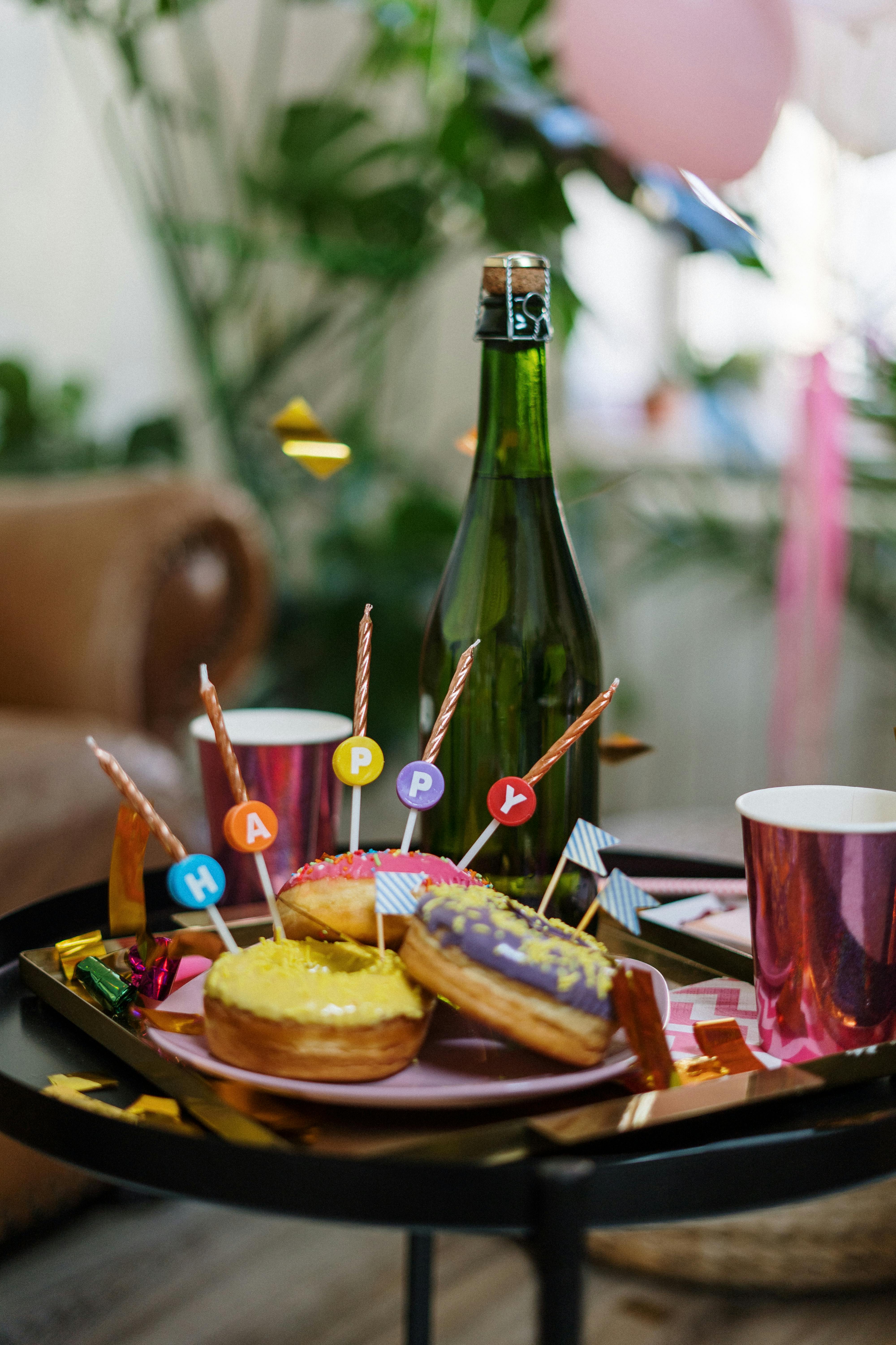 Colorful birthday celebration setup with doughnuts, champagne, and decorations.