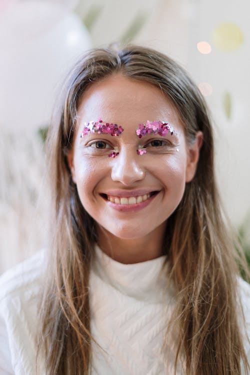 Woman in White Crew Neck Shirt With Pink and White Floral Face Paint
