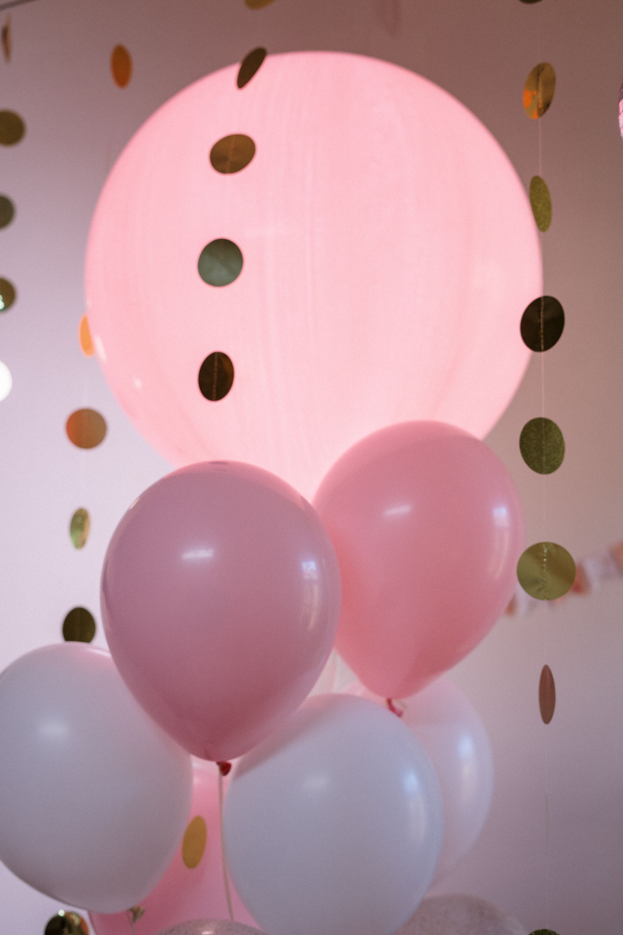 Pink and white balloons with a gold garland.