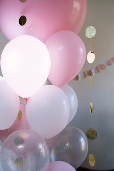 Charming pink and white balloons with glitzy decorations create a festive atmosphere.