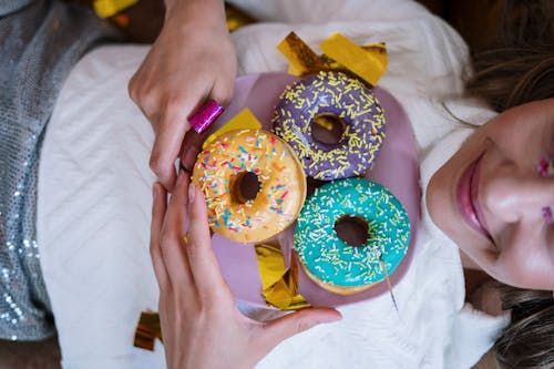 Person Holding Doughnut With Sprinkles