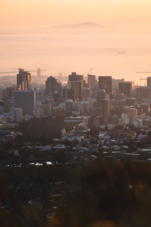 Free A breathtaking aerial view of a city skyline enveloped in morning mist during sunrise. Stock Photo