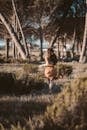 A Woman in Brown Dress Running on Grass Field