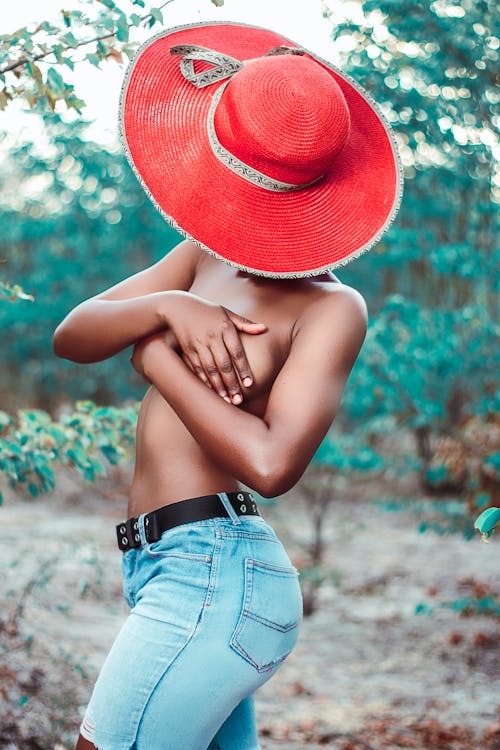 Black woman covering bare breast with hands