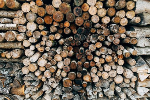 A close-up view of neatly stacked wooden logs, showcasing natural textures.