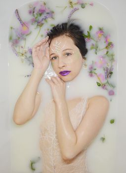 女人在花香牛奶浴中放松身心，享受宁静的护肤仪式