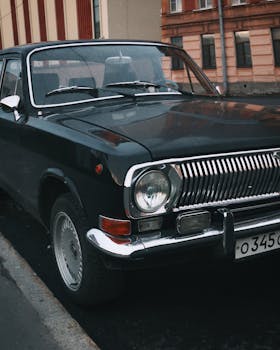 Vintage Volga car with chrome detailing parked beside urban buildings.