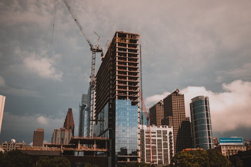 Modern skyscraper facade with cranes during construction
