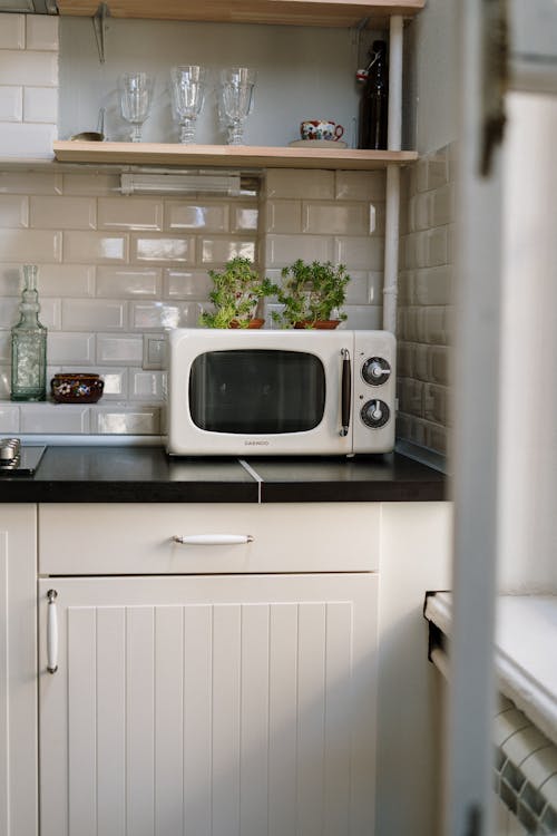 motorhome interior, kitchen, wood cabinets, microwave oven, 3-burner range,  window, mini blind, sink, tile backsplash; dinette seat, view into bedroom  Stock Photo - Alamy