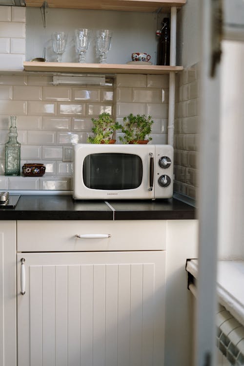 Silver Microwave Oven on White Wooden Cabinet